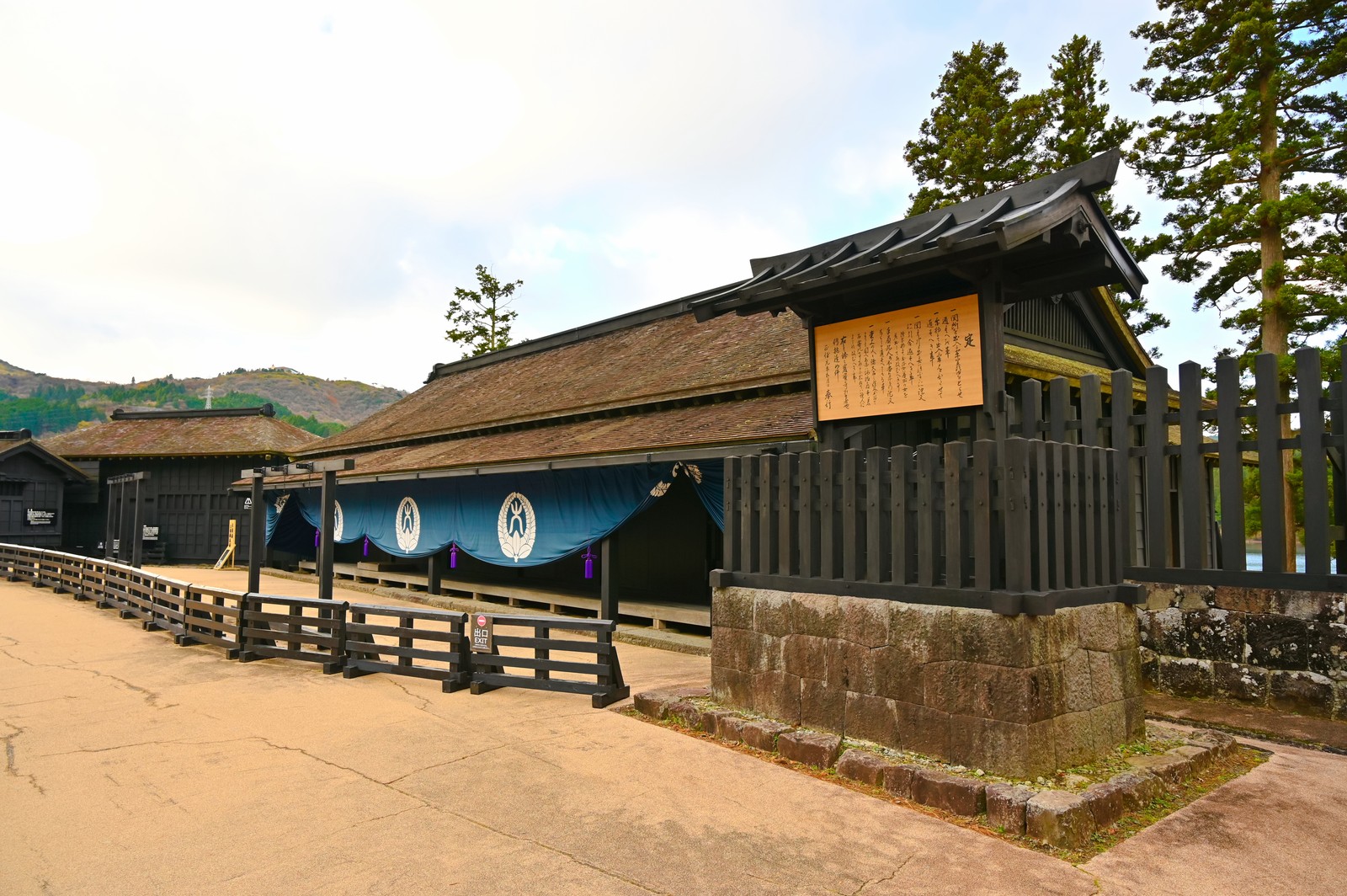 復元された箱根関所の大番所。紺の幕と柵、石垣が続く