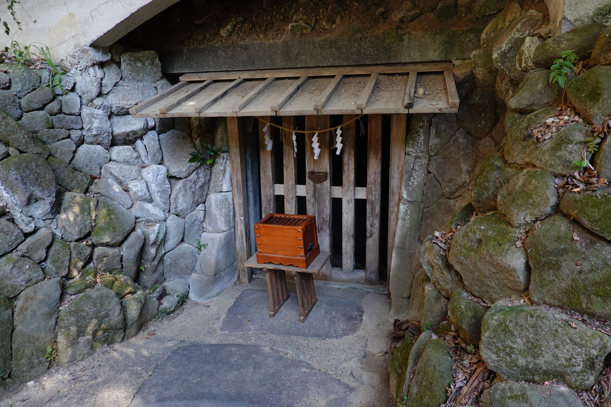 鎌倉宮の境内に残る土牢。岩をくりぬいた室に木の柵と注連縄がかけられている