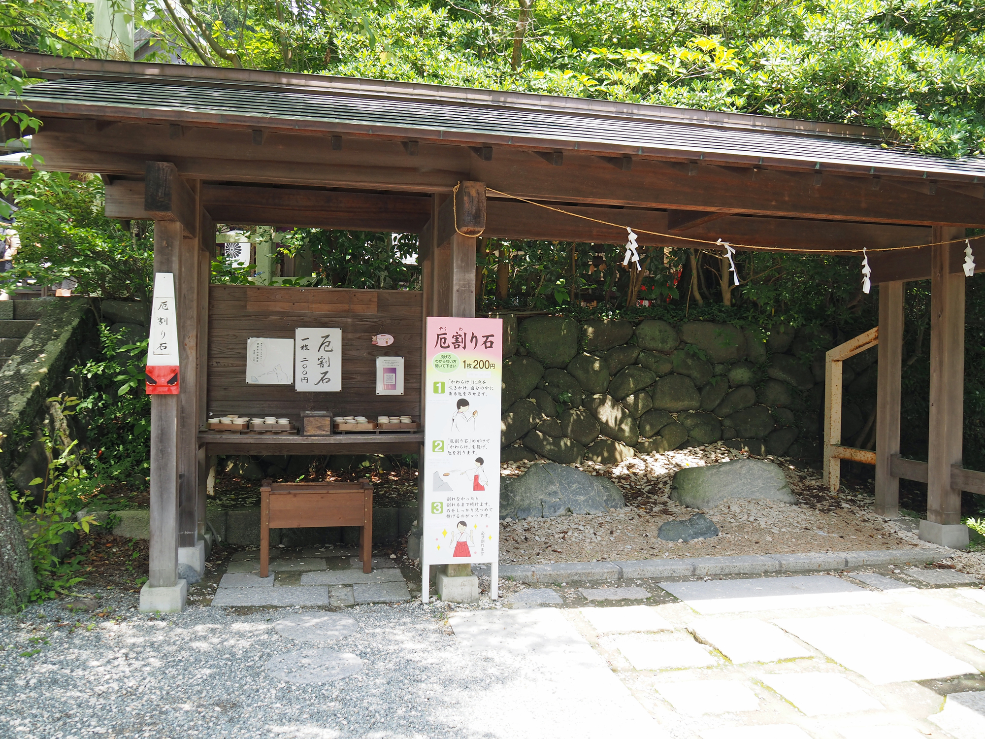鎌倉宮の厄割り石。授与所の前に案内板と素焼きの盃が並ぶ