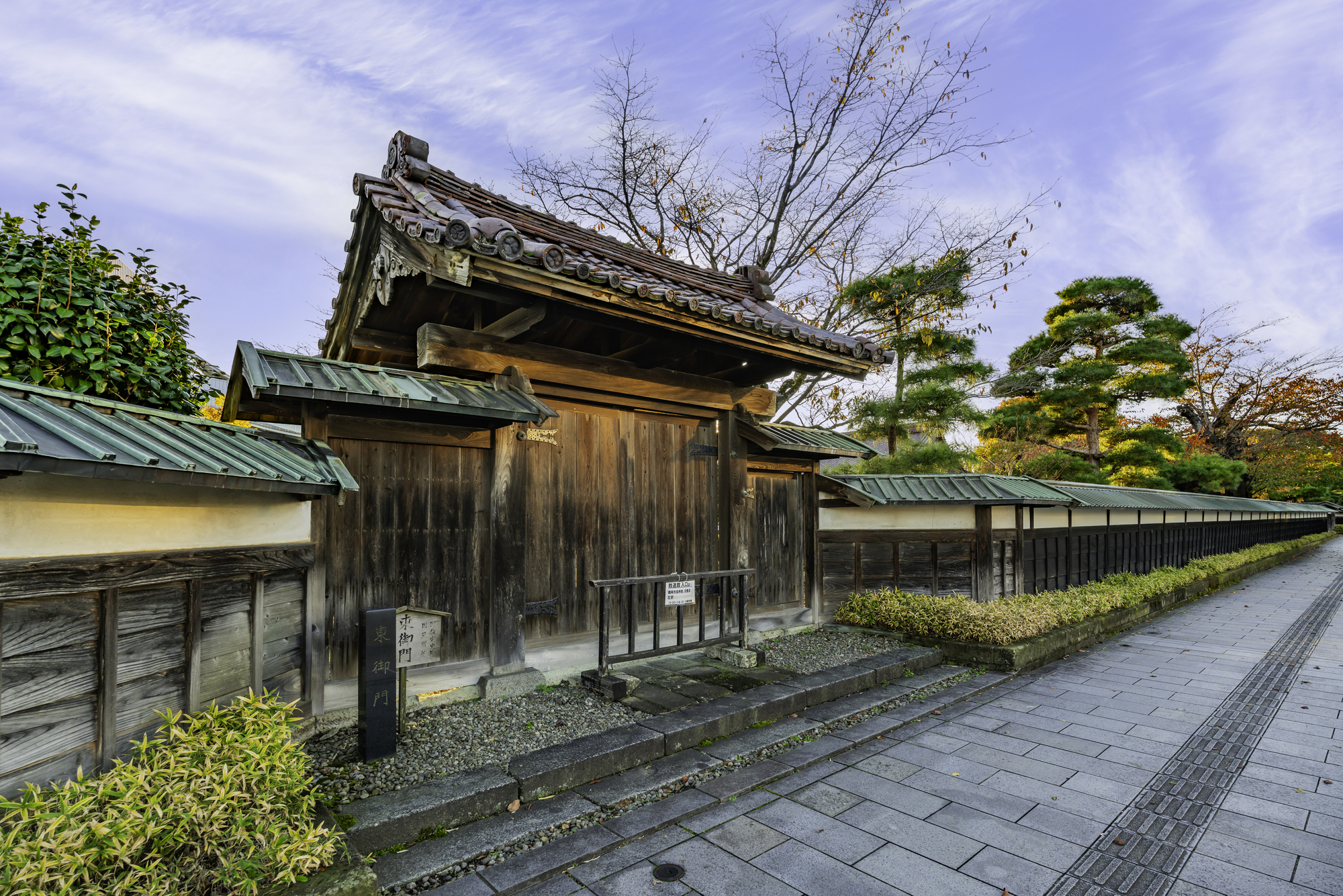 庄内藩校致道館の東御門。石碑が立ち、門の奥に塀と木立が続く