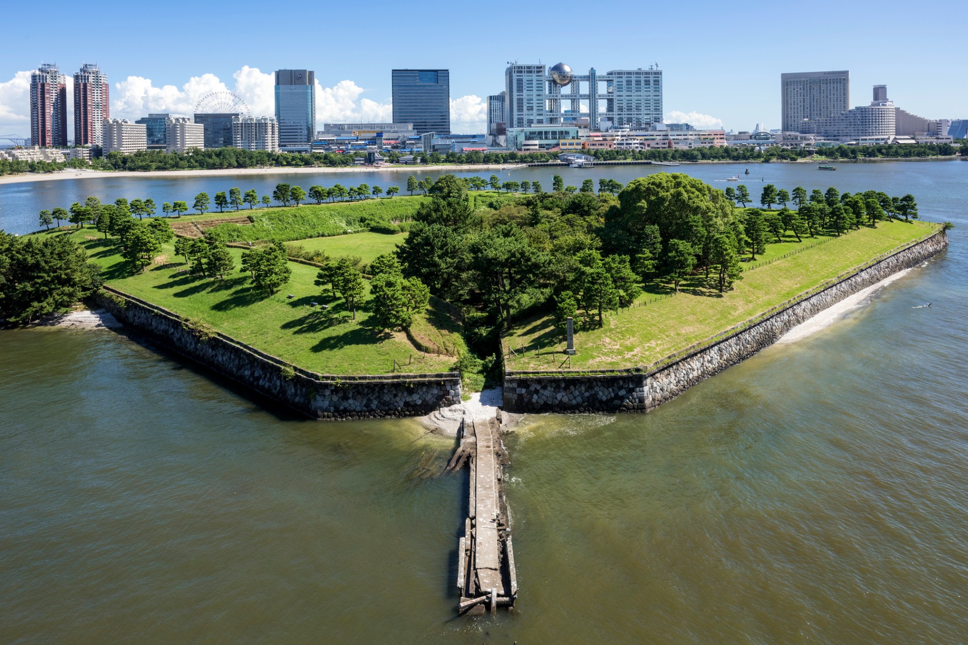 第三台場を上空から見た写真。石垣と土塁に囲まれた四角い島と、海へ伸びる船着き場跡が見える